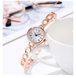 Orologio a catena in oro rosa con numeri romani sul bordo di una tazzina da caffè