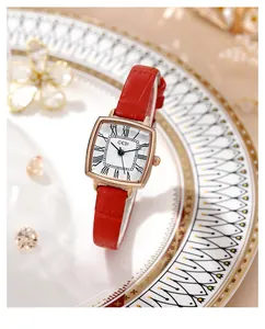 Detail of red croc-embossed leather strap and rose gold square quartz watch