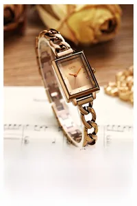 Macro shot of rose gold rectangular alloy watch with elegant metal chain bracelet