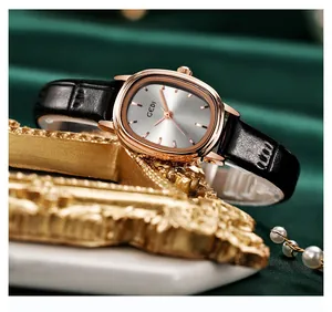Gros plan d'une montre ovale vintage rose doré sur velours vert et cadre doré élégant