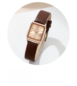 Détail de la montre rectangulaire en or rose avec cadran champagne et bracelet en cuir brun