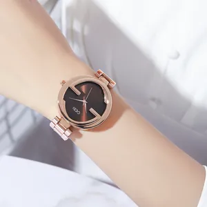 Montre élégante en acier inoxydable or rose avec cadran marron et motif G portée au poignet