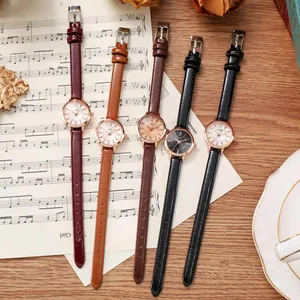 Groupe de montres à quartz élégantes pour femmes avec bracelet cuir sur papier musique