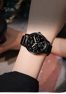 Vue détaillée de la montre GEDI en cuir noir avec index dorés portée au poignet