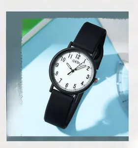 Macro shot of a black silicone watch strap with soft texture and a round white clock face