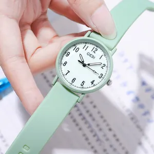Minimalist mint green silicone quartz watch with white dial and black numerals held in hand