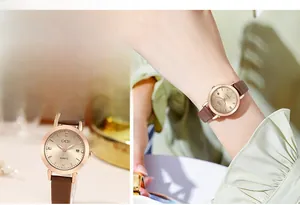 Macro detail of GEDI women's watch with rose gold case, date window, and brown leather strap