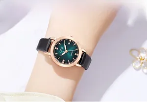 Close-up of women's quartz watch featuring a green sunray dial and rose gold metal case