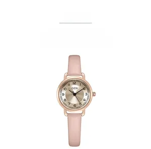 Macro detail of champagne gold dial with pink leather strap of a vintage quartz watch