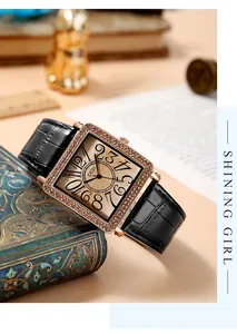 Detail of luxury square rose gold watch with crystal bezel on vintage blue book