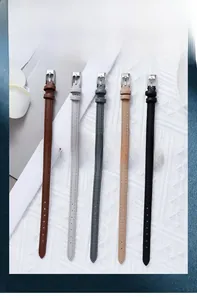 Detailed close-up of five minimalist quartz watches with narrow leather straps on white background
