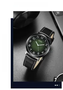 Detail of vintage men's quartz watch with green dial and black leather strap on desk
