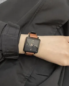 Close-up of GEDI square dial watch with brown leather strap worn on female wrist