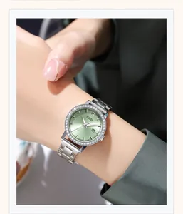 Close-up of luxury women's watch featuring a green sunray dial and rhinestone bezel