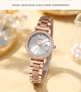 Detail of rose gold quartz watch with rhinestone bezel and date window on white dial