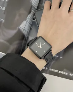 Close-up of a square quartz watch with rhinestone markers and a black crocodile leather strap