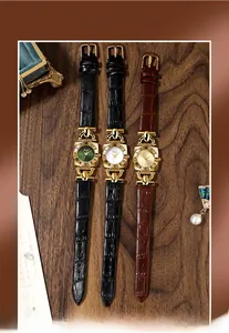 Close-up of three vintage square watches with leather straps and Roman numeral dials