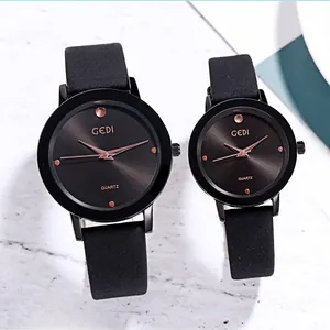 Close-up of minimalist black quartz couple watches with rose gold hands and matte leather bands