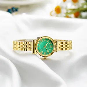 Elegant gold quartz watch with emerald green Roman dial on white silk background