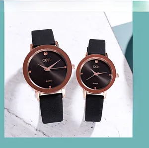 Close-up of minimalist rose gold quartz watches with black leather straps on marble
