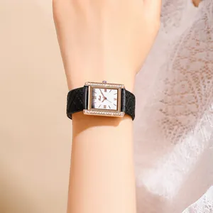 Detail of square rose gold watch with diamond bezel and black quilted leather strap