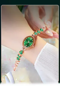 Nahaufnahme einer roségoldenen Blätterarmbanduhr mit grünem ovalem Zifferblatt und Stein