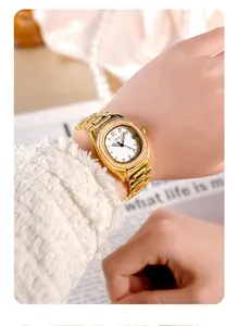 Nahaufnahme einer goldenen Damenuhr mit Diamantlünette und Kalender am Handgelenk