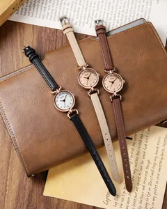Detailed close-up of retro leather quartz watches displayed on vintage notebook