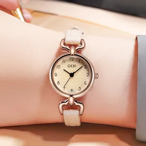 Close-up of minimalist GEDI watch with rose gold case and cream leather strap