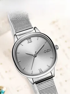 Close-up of silver mesh strap watch with sunray dial and Roman numeral markers
