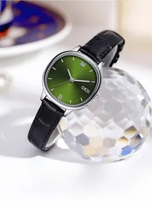 Makroaufnahme einer Quarzuhr mit grünem Zifferblatt und schwarzem Lederarmband auf Kristall