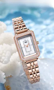 Dettaglio dell'orologio quadrato in oro rosa con zirconi su sfondo azzurro effetto acqua