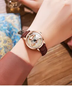 Macro view of leather strap and deer motif dial on rose gold quartz watch