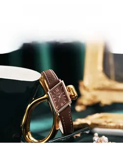 Close-up of vintage rhombic dial watch with rose gold case and brown leather strap