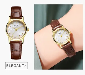Elegante Gold-Quarzuhr mit Perlmutt-Zifferblatt und braunem Lederarmband auf grüner Seide