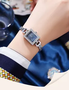 Detailed close-up of a square silver quartz watch with a blue mother-of-pearl dial and rhinestones