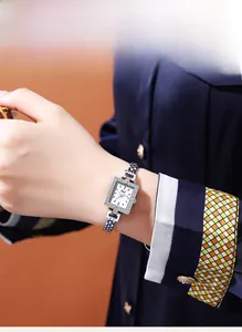 Detailed close-up of a square quartz watch with a diamond-set bezel on a metal bracelet