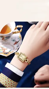 Detailed shot of a gold square quartz watch with a crystal bezel on a woman's wrist