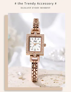 Close-up of elegant rose gold rectangular watch dial with crystals and mother of pearl
