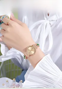 Nahaufnahme einer rotgoldenen Uhr mit grünem Jade-Akzent und Diamanten am Handgelenk