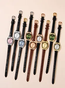 Flat lay display of oval quartz watches with leather straps in various colors