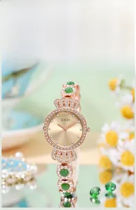 Makroaufnahme der GEDI Roségold-Uhr mit smaragdgrünen Steinen und Diamant-Zifferblatt