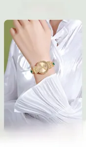Detail einer Vintage-Golduhr mit Smaragd-Schleife und Diamantlünette am Handgelenk