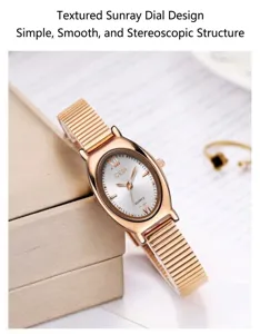 Detail van retro ovaal roségouden horloge met zonnestraal wijzerplaat en klaverring