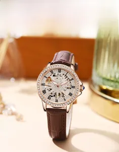Close-up of star-shaped skeleton watch dial with rose gold crystal-set bezel and leather strap