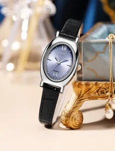 Close-up of elegant oval quartz watch with blue sunray dial on a vintage gold stand
