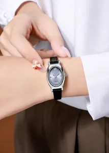 Close-up of elegant tonneau-shaped silver watch with Roman numerals and black leather strap