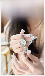 Détail d'une montre femme avec cadran à texture ondulée et aiguilles en acier bleu
