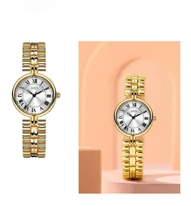 Detail view of a vintage round gold watch with Roman numerals and sunburst white dial