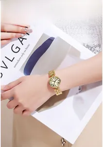 Close-up of vintage gold quartz watch with Roman numerals on a champagne dial